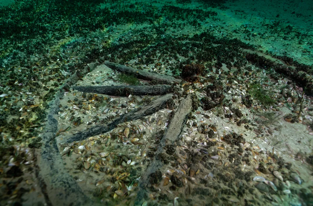 A wagon wheel in sediment at the bottom of a lake
