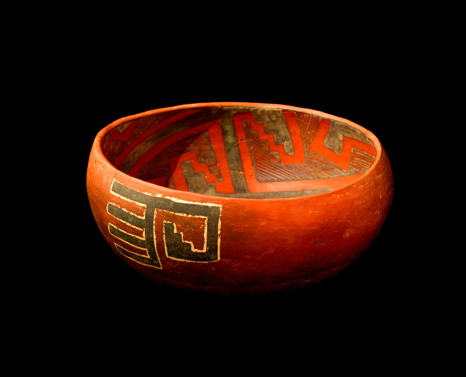  A red and black bowl with geometric designs painted on it is believed to bring good luck.