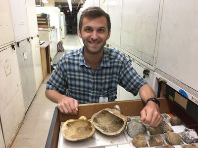 The National Museum of Natural History’s newest curator in the paleobiology department, Dr. Stewart Edie, opens a drawer with mollusk fossils in the museum’s invertebrate paleobiology collection. (Katie Collins, National History Museum, London)
