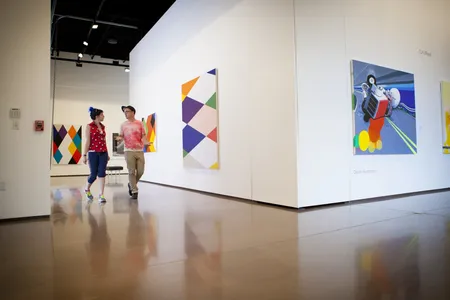 Visitors walking through an indoor art gallery