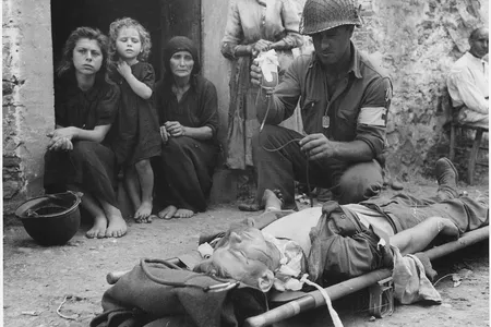 Private Roy W. Humphrey is being given blood plasma after he was wounded by shrapnel in Sicily in August 1943.