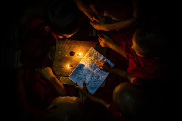 Novices reading together and connected with their soul of concentration by a single book of knowledge.