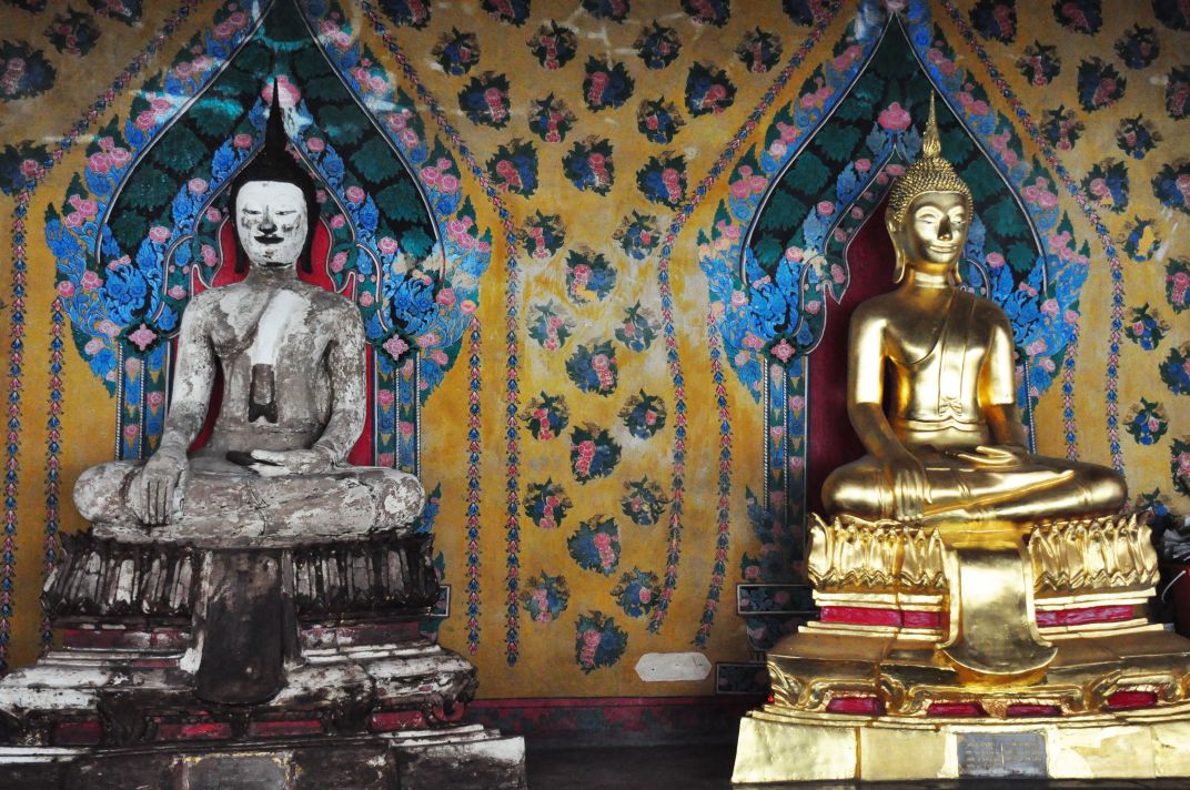 Two Buddhas sit by each other, one golden and one not Smithsonian