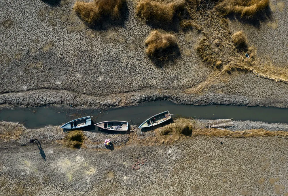 Dried up river with three boats on the bank