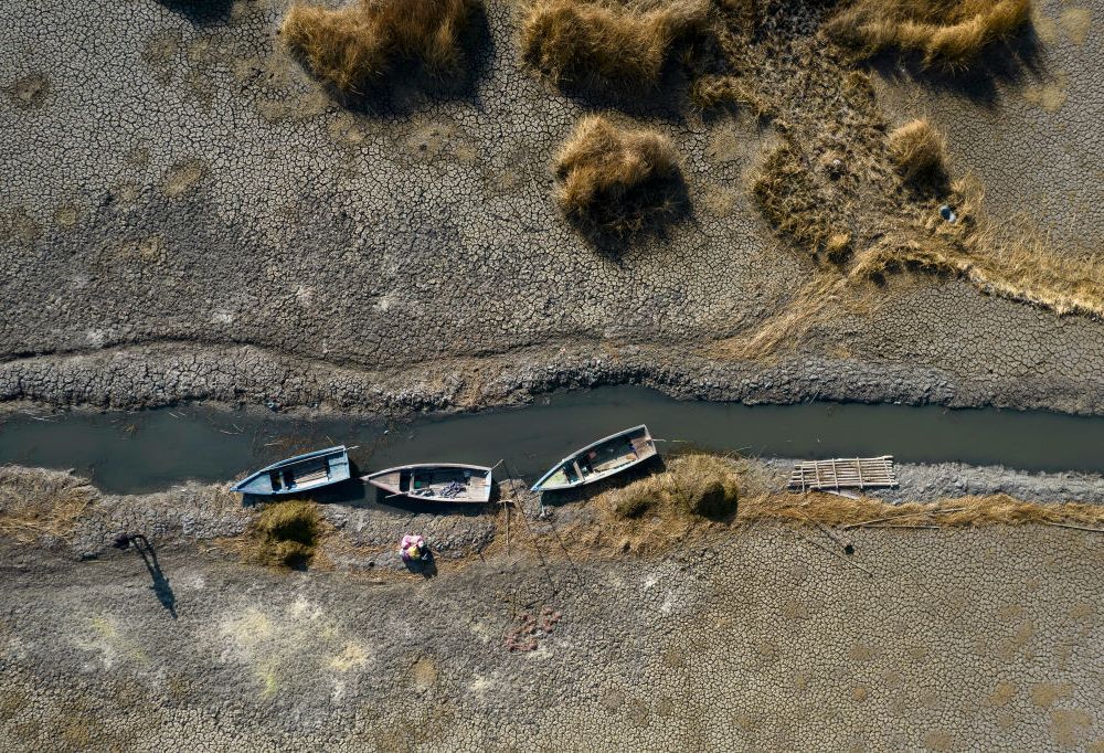 Dried up river with three boats on the bank