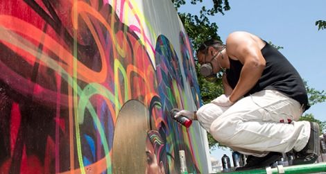 An artist works on a mural installation in the “Citified” program.
