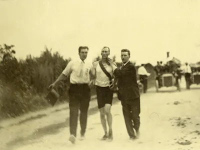 Attendants assist Thomas Hicks, an American runner who consumed strychnine, egg whites and brandy during the race.
