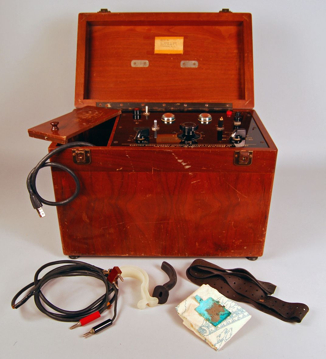 Red wooden electroshock machine with wires and other accessories