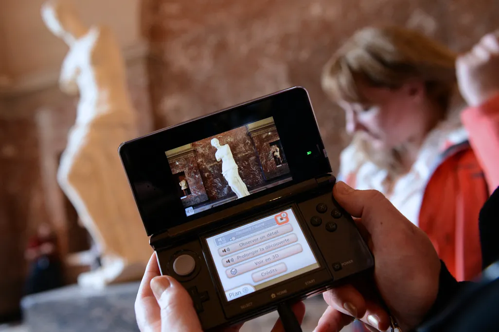 Person using a handheld electronic device in a museum