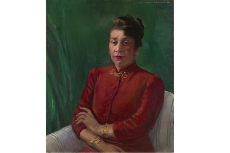 Distinguished in a high-collared, red shirt and gold jewelry, Alma Thomas wears her hair up and looks directly at the viewer. Her arms are crossed loosely, and she sits before a green background.