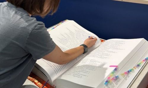 woman looks through a large book of names