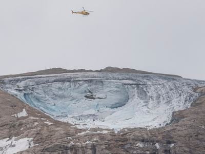 Helicopters fly above the collapsed section of the Marmolada glacier in Italy.

