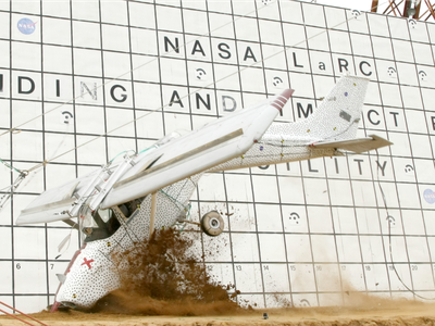 A donated Cessna sporting a speckled livery undergoes a controlled crash at the Langley center; the dots allow cameras to track crash loads.