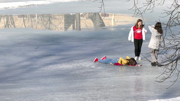Children playing on frozen pond on the arrival of spring. thumbnail