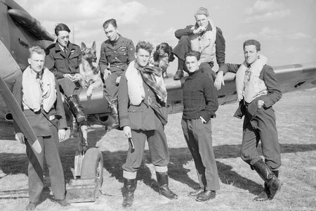Pilots of No. 19 and No. 616 Squadrons—along with Flash the Alsatian and Rangy the spaniel—pose by a Spitfire. “How should you live if you are 20 and will be dead by the end of the summer?” asks Chaplain Guy Mayfield.