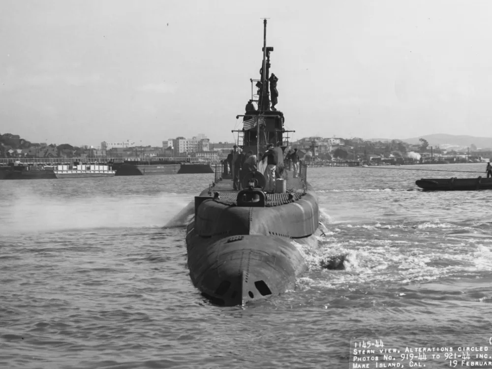 Black and white photograph of surfaced submarine in the water