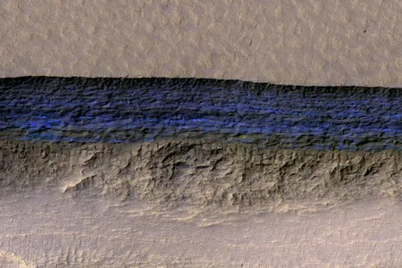 Underground ice exposed on a steep Martian slope appears bright blue in this enhanced-color view from NASA's High Resolution Imaging Science Experiment (HiRISE) camera in Mars orbit.