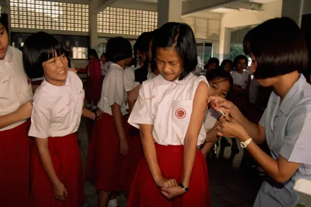 School girls line up to receive vaccinations between classes. 
