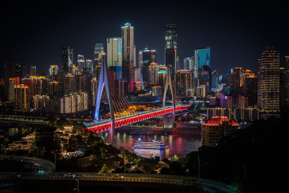 This striking photograph captures the city’s vibrant skyline at night, with the stunning neon-red bridge standing proudly at the center. Surrounded by a sea of illuminated skyscrapers, this scene radiates an epic sense of Chinese modernity and grandeur.