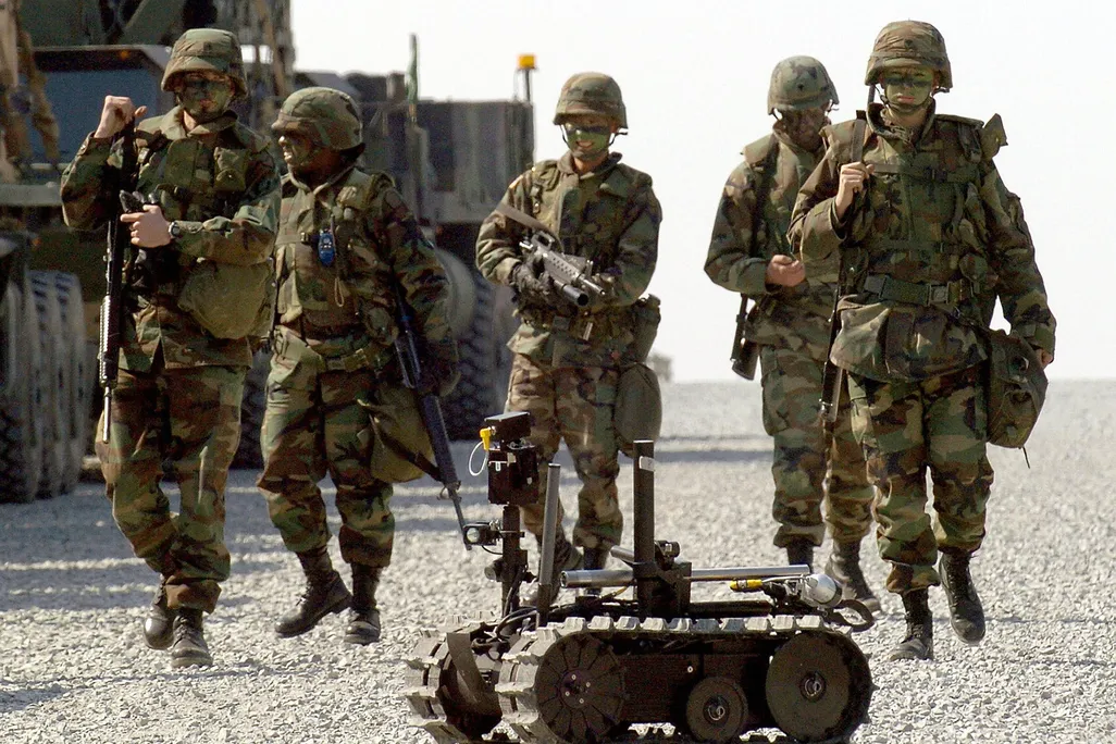 US soldiers walk behind a military robot during military exercises by US and South Korea troops