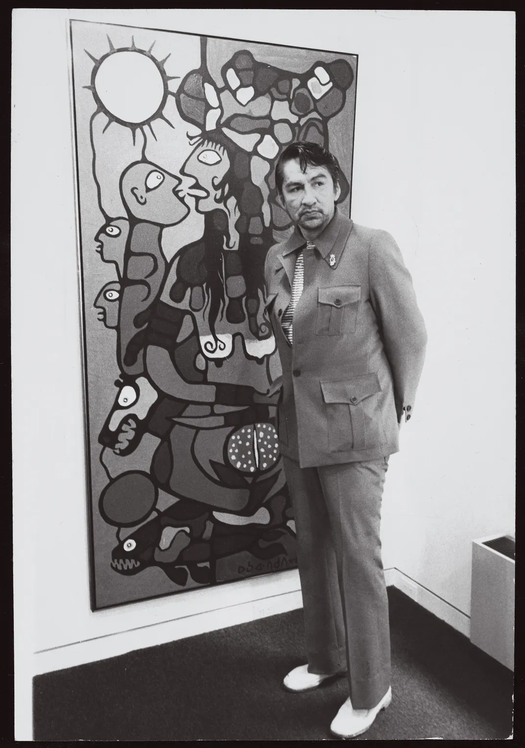 Morrisseau, known as the “Picasso of the North,” at the Pollock Gallery in Toronto, 1975, beside a painting of mother and child—a frequent theme.