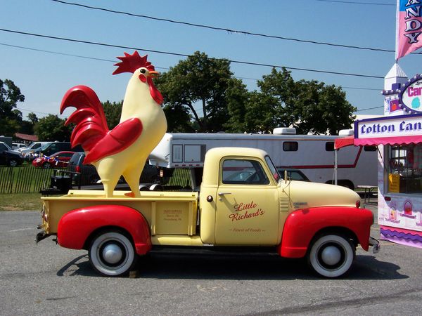 Giant chicken on a pickup truck at the fair. thumbnail