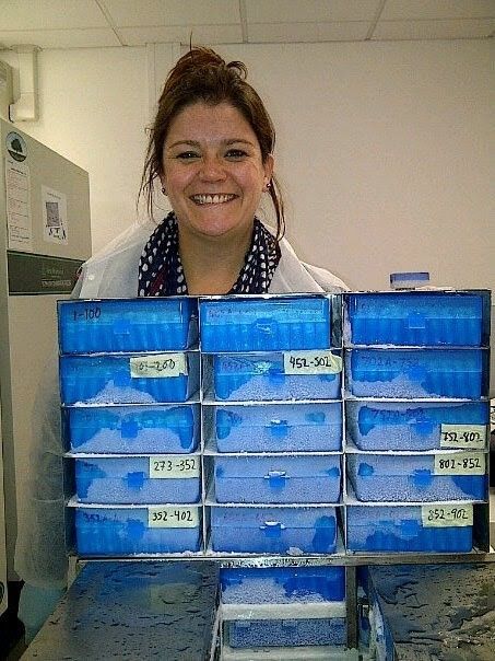 A person with a stack of blue boxes.