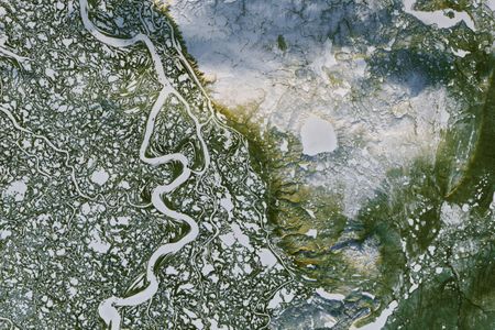 This NASA Landsat image shows the Mackenzie River surrounding the town of Inuvik, and the uniquely pock-marked landscape of this delta. 