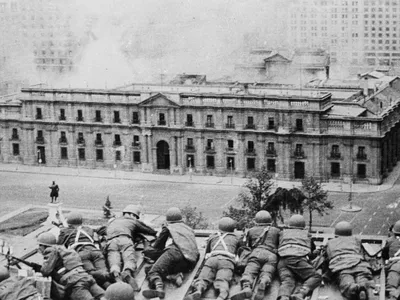 Soldiers supporting the coup led by Gen. Augusto Pinochet take cover as bombs are dropped on the Presidential Palace of La Moneda in Sept. 11, 1973.