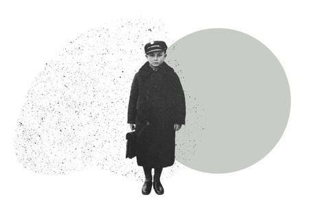 A boy in a long wool coat and hat holds a small case