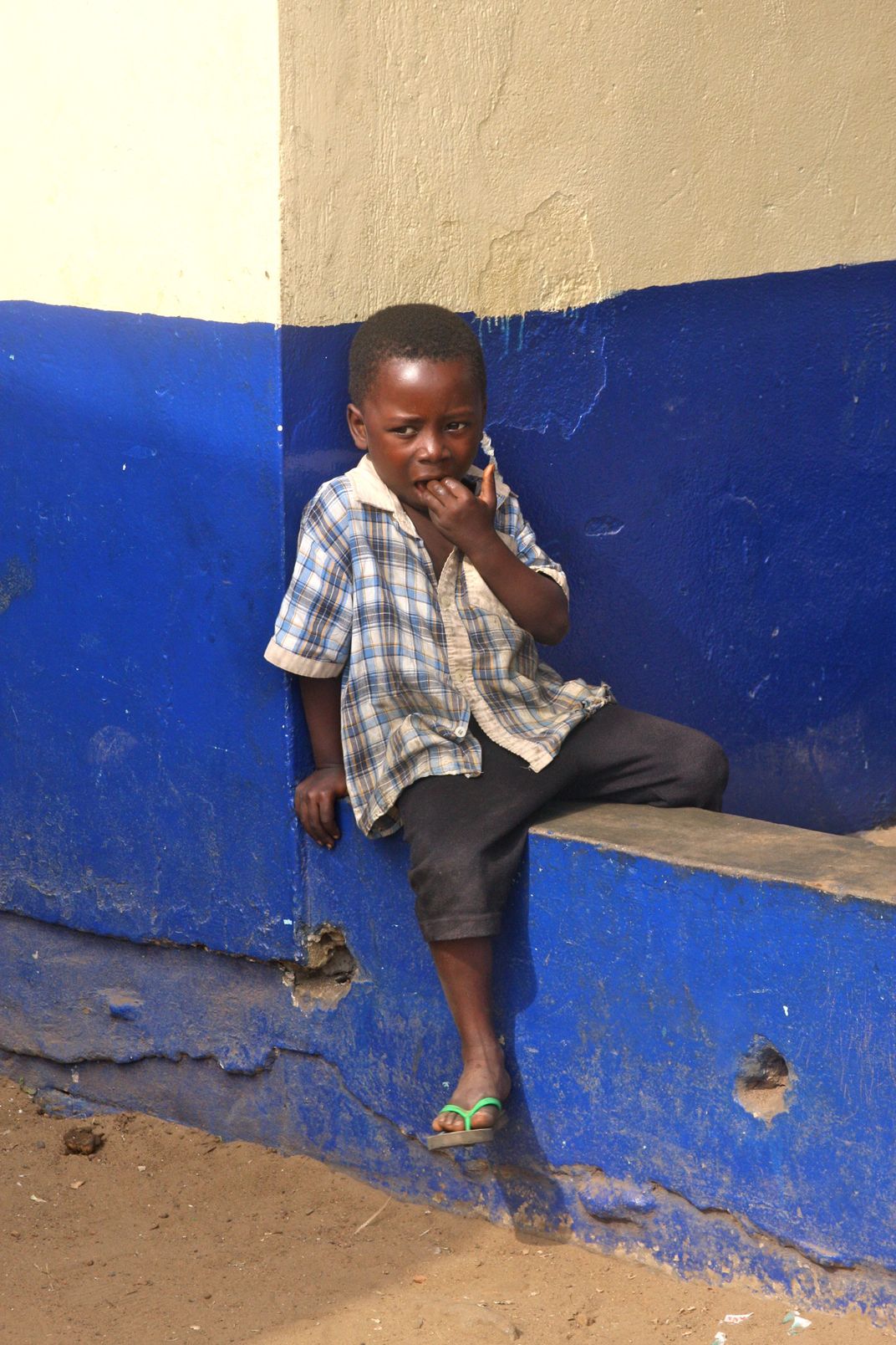 a-small-boy-waiting-on-a-ledge-on-the-side-of-the-street-smithsonian