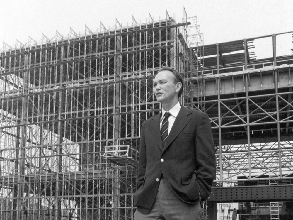 Michael Collins, the Museum's third director, stands before the steel skeleton of the new National Air and Space Museum in July 1974.