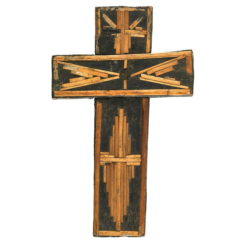 Wooden cross decorated with straw arranged in geometric patterns