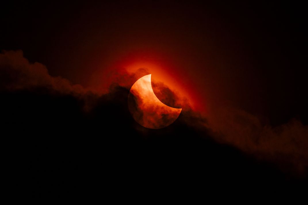 red crescent moon surrounded by dark clouds