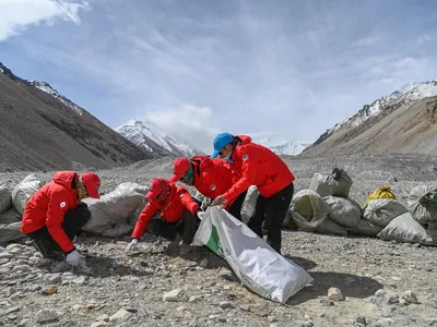 Climbers collect garbage from Mount Everest in 2020. In recent years, officials have implemented new regulations to help reduce trash on the mountain.