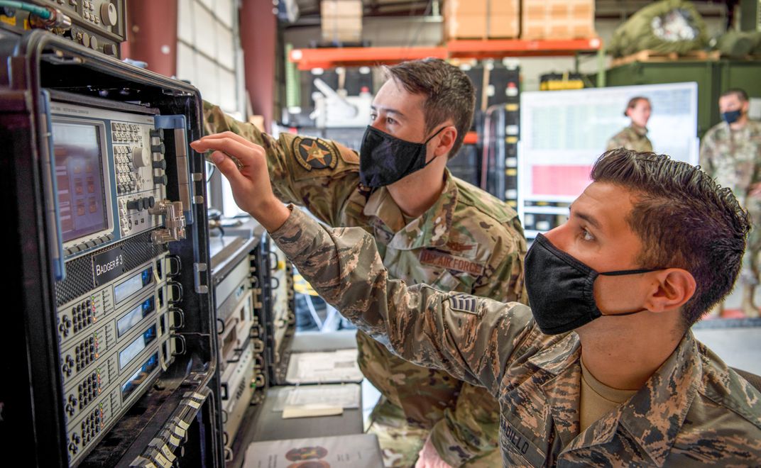 Space force members wearing masks using technology