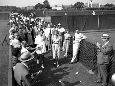 Althea Gibson leaves Forest Hills court accompanied by Alice Marble and applause of spectators.