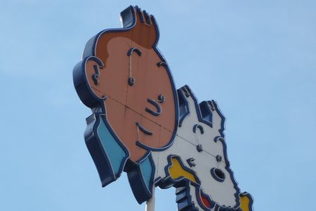Boy reporter Tintin and his dog Snowy portrayed in a sign. Although Tintin's later adventures are fairly innocent, the comic has dark roots.