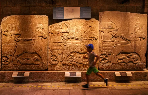 boy running in front of old sarcophagi thumbnail