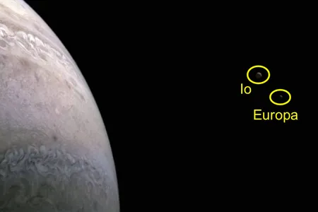 The moons appear as two blurry dots located close together in the upper right area of the image. Io, seen as a darker speck on the left of the two dots, is the most volcanically active world in the solar system. Europa is seen on the right and features a global ocean beneath its icy surface.&nbsp;