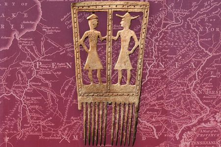 In this late 17th-century comb, created by a craftsperson from either the Seneca or Susquehannock peoples, two animated figures wearing frock coats—likely a Native American and a Euro-American—face one another. 