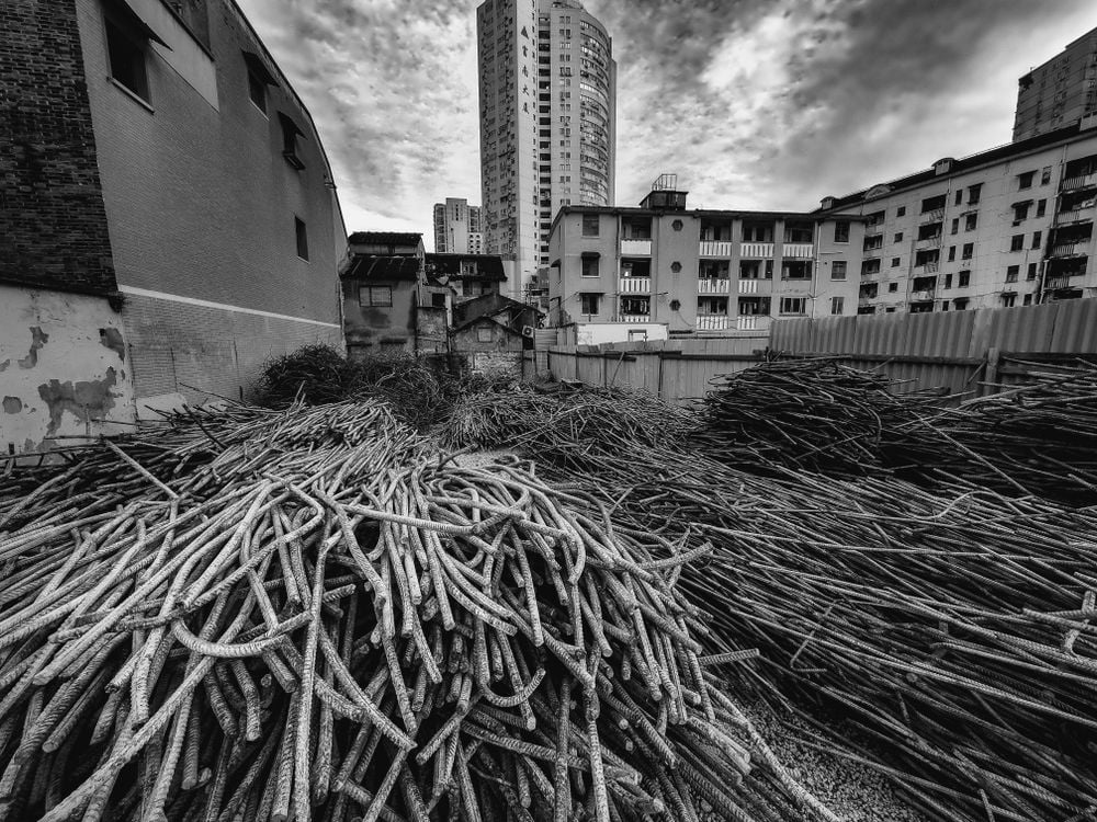 The modern high-rise buildings in the background are very different from the pile of rusty crossbars that are stacked in an old part of Shanghai. This black-and-white picture shows the point where decay and rebirth meet, representing how the city's environment is always changing with time.