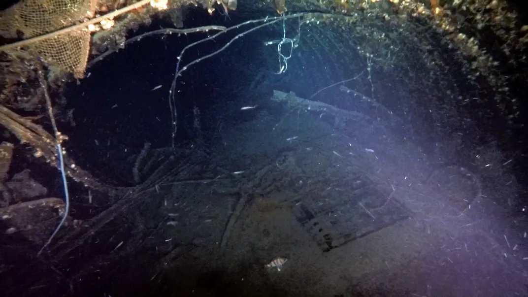 Murky underwater view of damaged submarine