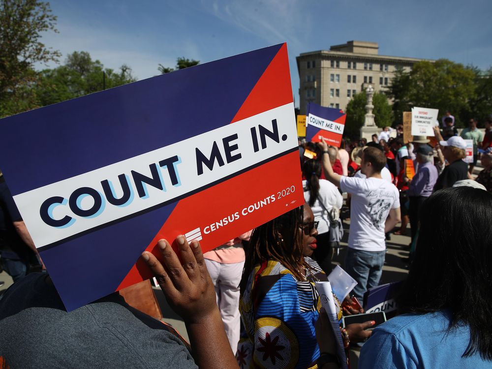 A protestor holds a sign that says "Count Me In"