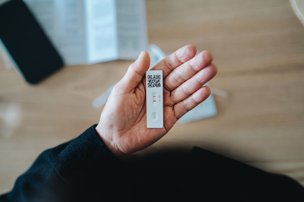 person holding a positive at-home covid test
