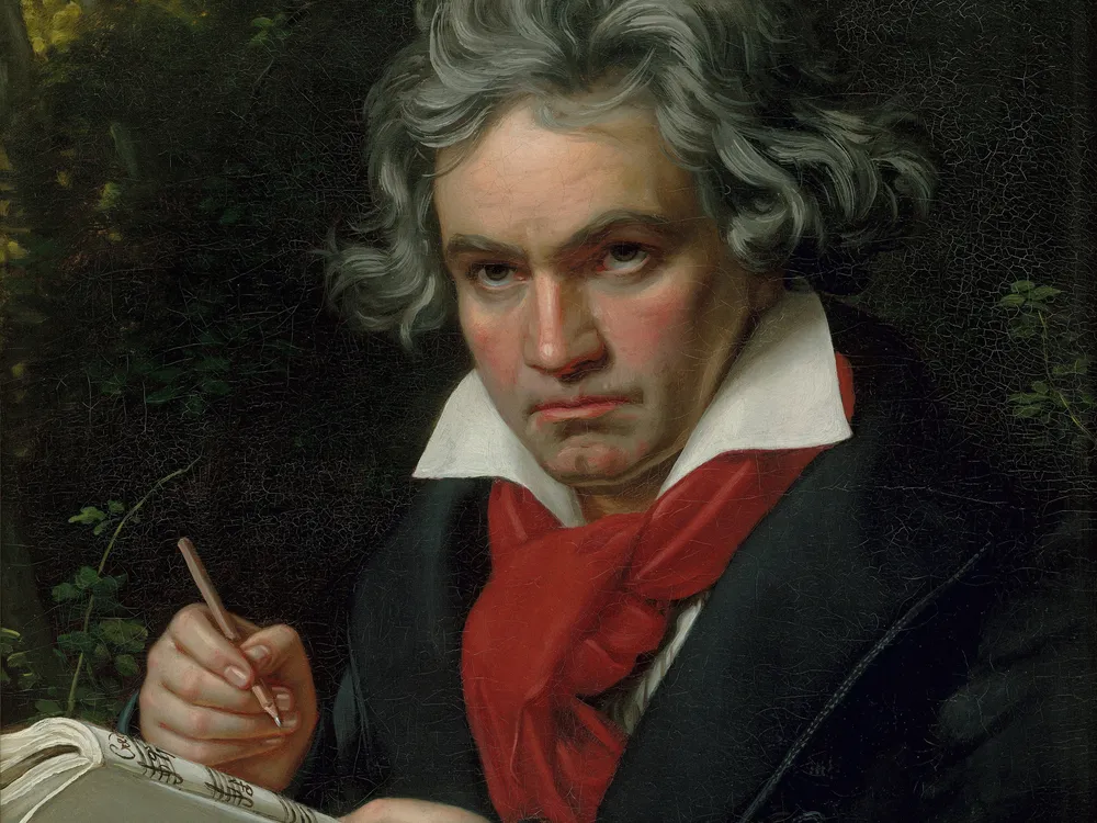 the composer beethoven wearing a black jacket and red scarf, pencil in and and a musical score in the other