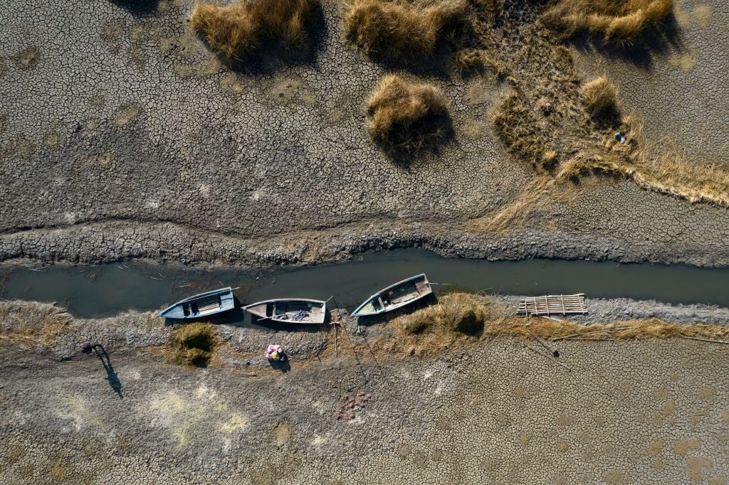 Dried up river with three boats on the bank