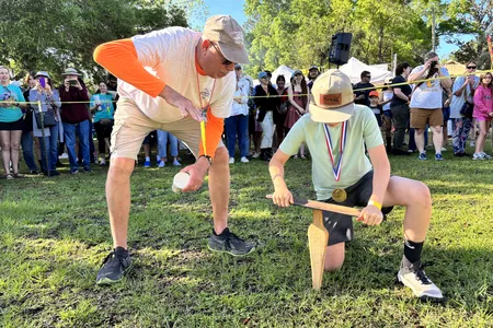 A festivalgoer shows a child how to "grunt" for earthworms.