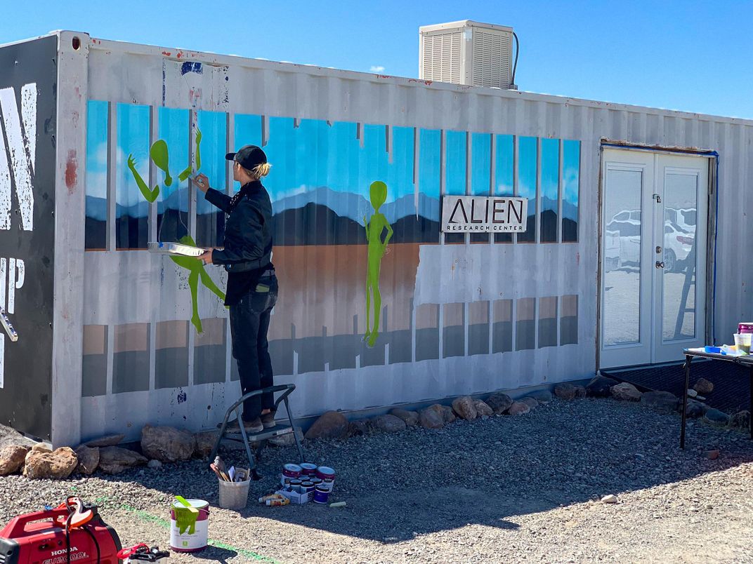 artist Brandy Whisenant paints a mural at the Alien Research Center