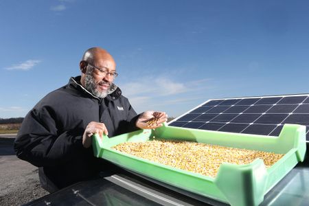 Klein Ileleji stands next to a dehydrator he invented.